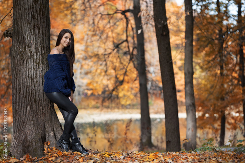 Beautiful young happy woman on a walk in the autumn forest