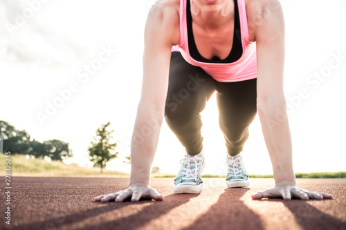 Close up low angle view of female warming up before run. training running trak photo