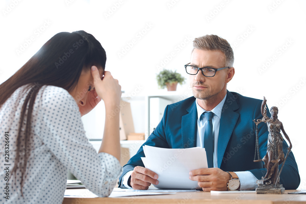 lawyer holding papers and working with upset client lawyer holding papers and working with upset client