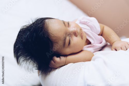 Baby girl sleeping in mother's arms