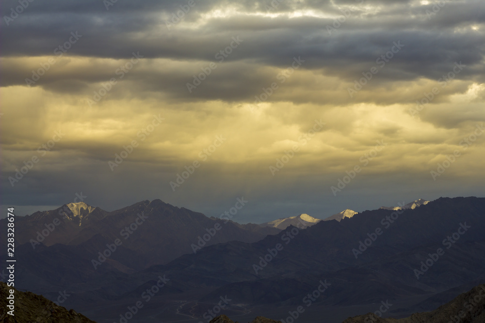 Fototapeta premium sunlight in the evening sky over snowy mountains