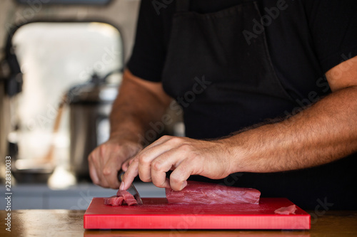 Obraz na płótnie Crop chef slicing fresh tuna w salonie