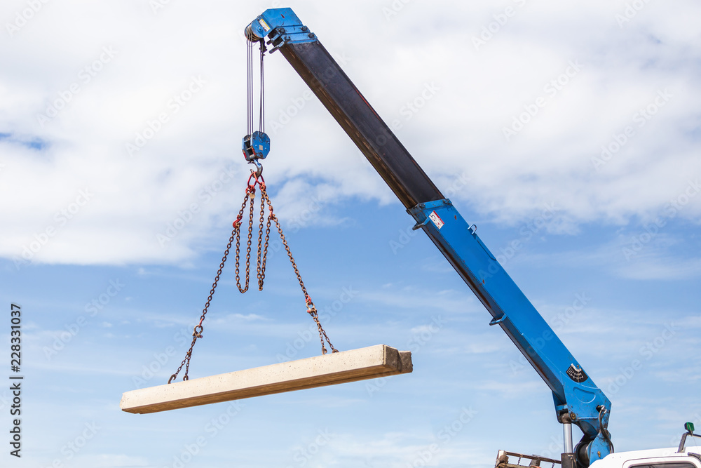 Construction worker unloading concrete stake from truck. Construction worker unloading concrete stake from truck.
