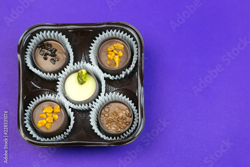 Five chocolates on a colored background. Candy with different fillings in a package of 5 pieces.