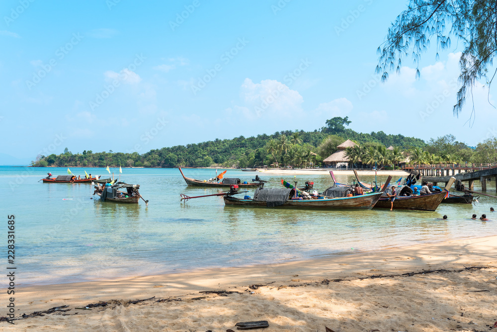 Kids swimming, sea Gypsies on their long-tail boats  at the east-side beach named Ao Mae Mai on the island Ko Phayam 