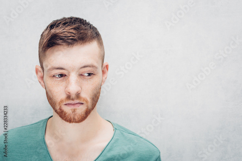 Bilde på lerret Sad young man on a gray background. Closeup portrait.