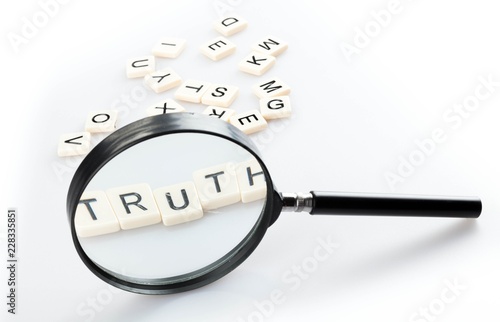 Concept image of a magnifying glass isolated  with a word TRUTH photo