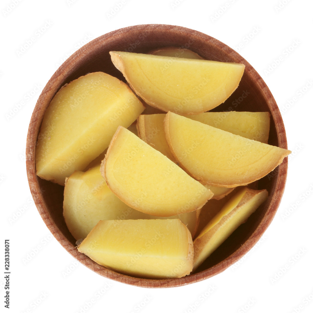 slices of ginger in wooden cup isolated on white. top view