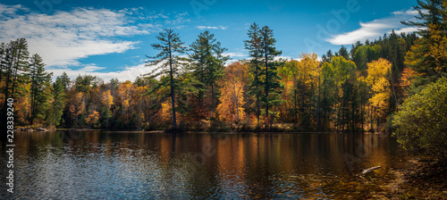 Panoramic view of Mountain Pond reflecting autumn colors in the Adirondacks, New York