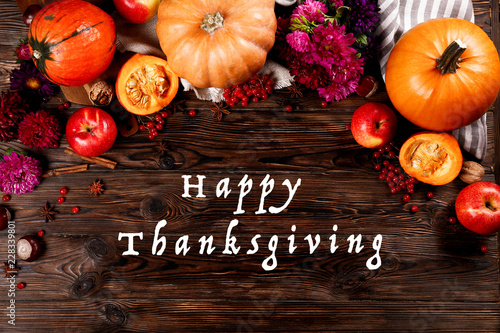 Happy thanksgiving concept. Still life composition with pumpkin and oher fruits and vegetble small decoration with funny font text white text. Wood textured table background. Top view, close up. photo