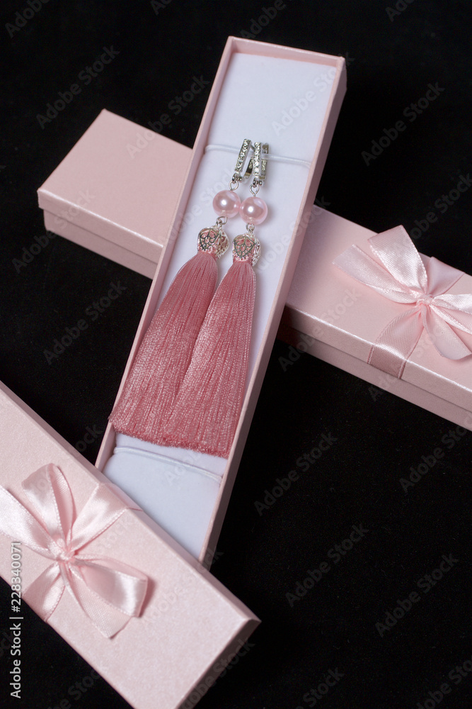 Earrings made of viscose handmade. Together with wrapping gift boxes. Against the black background. - obrazy, fototapety, plakaty 