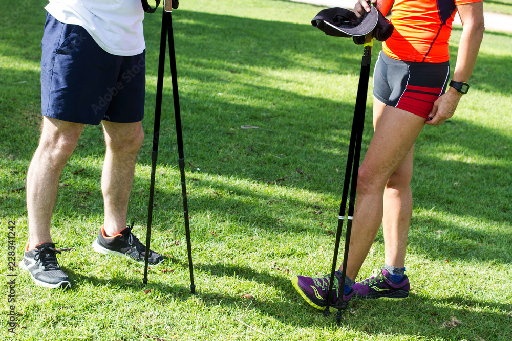 Obraz premium Hombre y mujer Pareja practicando nordic walking en el parque al aire libre