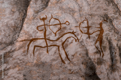 image of ancient hunters with bow and arrow on the wall of the cave. era, era, archeology.
