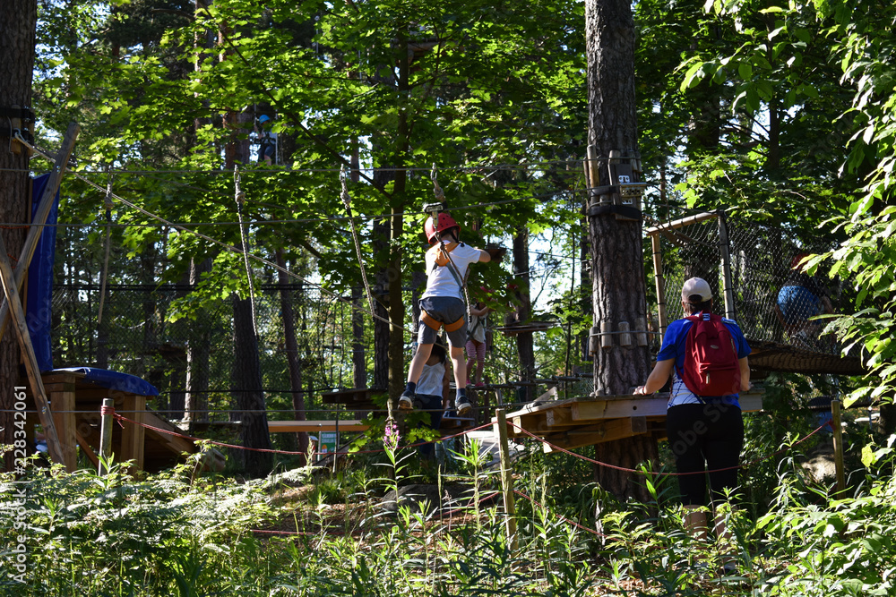 Boys and girls try to conquer these obstacles for kids in an adventure park with the supervision of their parent. Boys and girls try to conquer these obstacles for kids in an adventure park with the supervision of their parent.