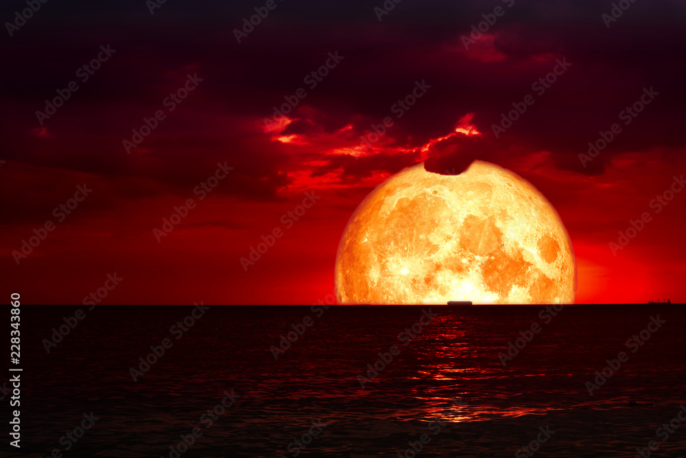 Fototapeta premium półkrwi księżyc na morzu nocnym i sylwetce czerwona chmura