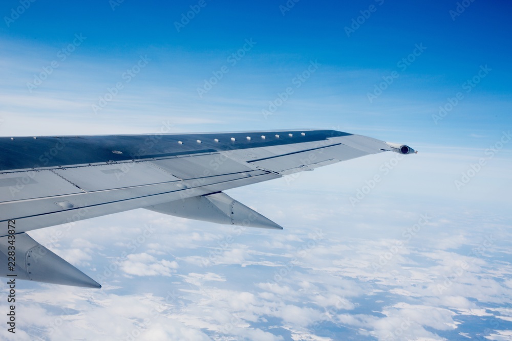 Airplane Wing Out of Window with Clouds and Sky Airplane Wing Out of Window with Clouds and Sky