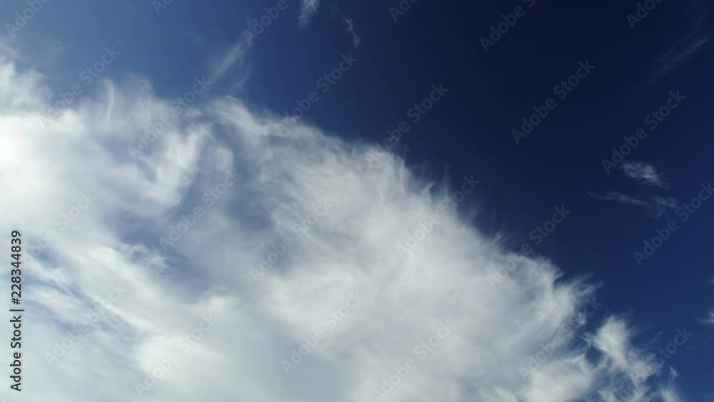 Timelapse of white clouds under a dark blue sky. Cirrus and cirrostratus run fast away in a diagonal composition. Timelapse of white clouds under a dark blue sky. Cirrus and cirrostratus run fast away in a diagonal composition.