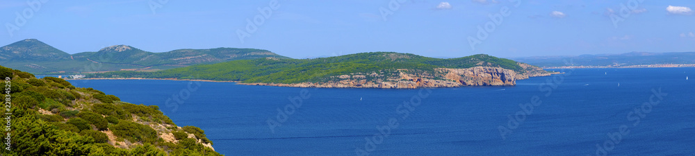 Alghero, Italy - Panoramic view of the Gulf of Alghero with cliffs of Punta del Giglio and city of Alghero in background