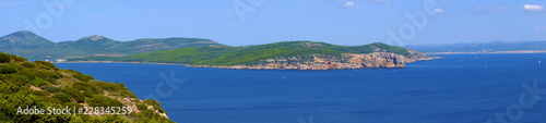 Alghero, Italy - Panoramic view of the Gulf of Alghero with cliffs of Punta del Giglio and city of Alghero in background