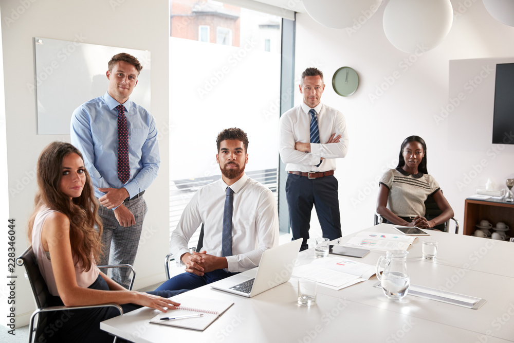 Fototapeta premium Portrait Of Businessmen And Businesswomen Meeting Around Table In Modern Boardroom