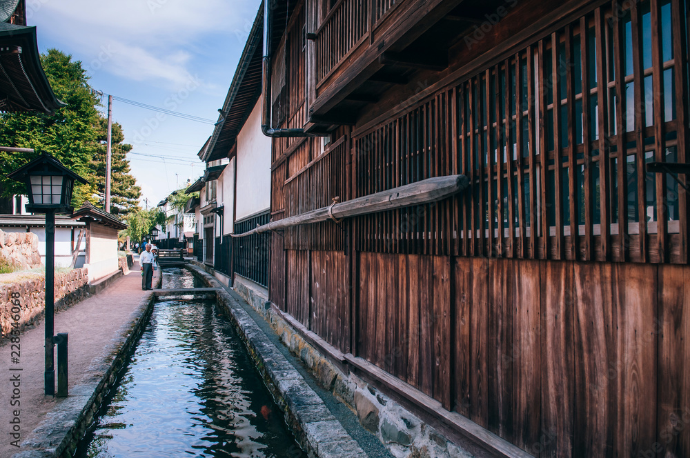 Old houses and Japanese tourist on street and small natural stream of Hida Furukawa town, Gifu. Japan