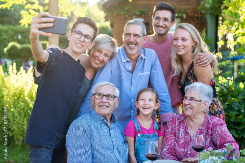 during a bbq a teenager does a selfie with the whole family © jackfrog