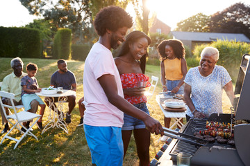 Couple grilling at a black multi generation family barbecue