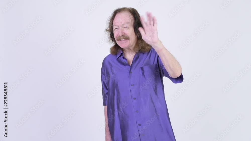 Happy senior man with purple silky shirt waving hand Happy senior man with purple silky shirt waving hand