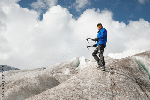 Traveler in a cap and sunglasses standing in the snowy mountains on the glacier. Traveler in a natural environment