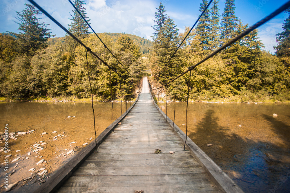 Suspension bridge. Landscape view of long wooden suspension bridge above river. balance