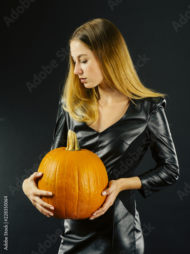 Beautiful young woman holding pumpkin for Halloween