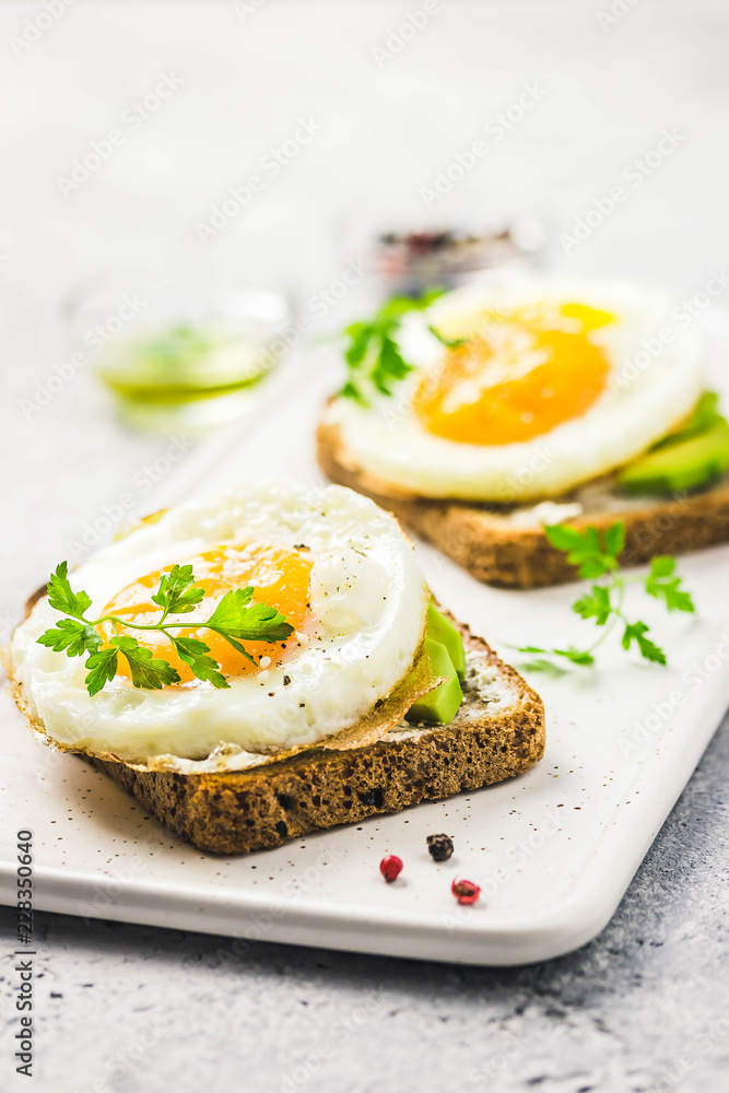 Avocado, cream cheese and fried egg sandwich. Selective focus, space for text.
