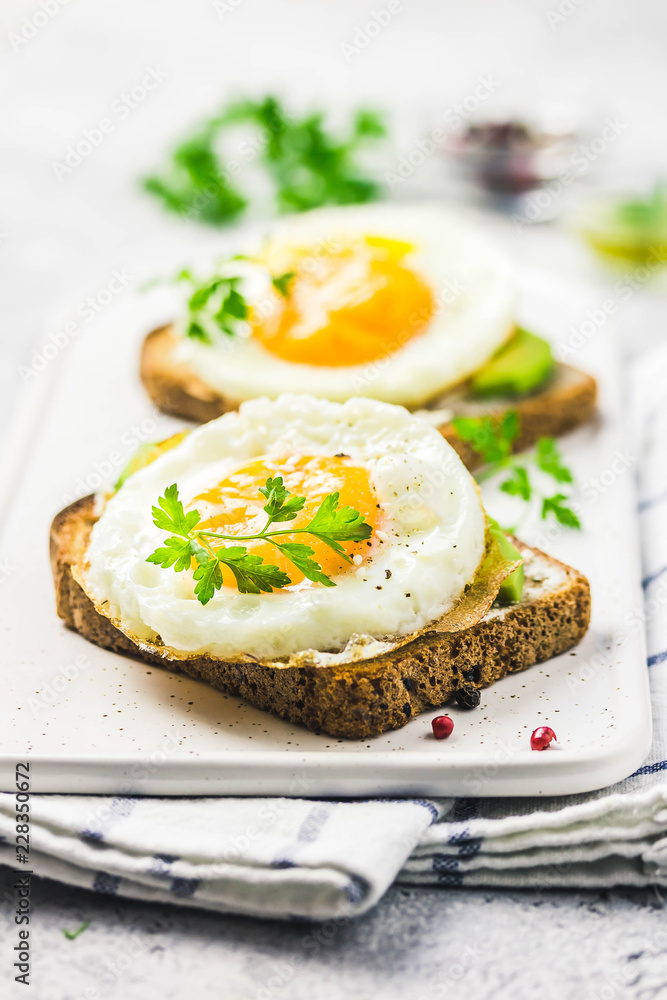 Avocado, cream cheese and fried egg sandwich. Selective focus, space for text.