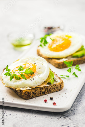 Avocado, cream cheese and fried egg sandwich. Selective focus, space for text.