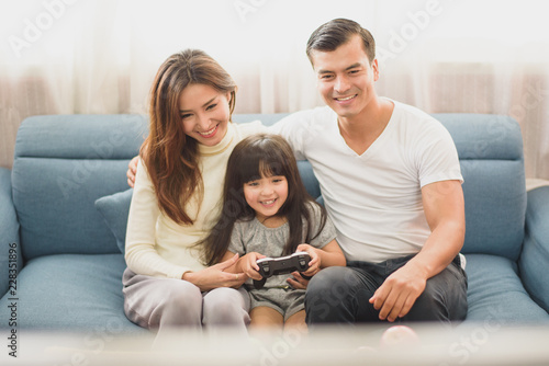 sofa; mother; sitting; young; couch; adult; family; happiness; living; home; two; indoors; father; play; couple; female; together; male; girl; caucasian; beautiful; love; man; woman; room; relationshi photo