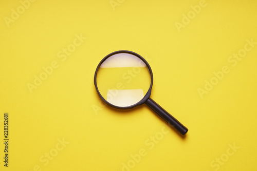 magnifying glass magnifier loupe search symbol on yellow background with copy space
