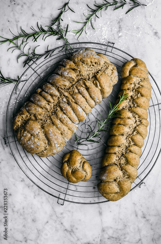 Overhead view of rosemary, garlic, and olive oil plaited rye bread on cooling rack photo