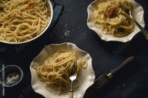 Italian pasta carbonara with bacon on dark background