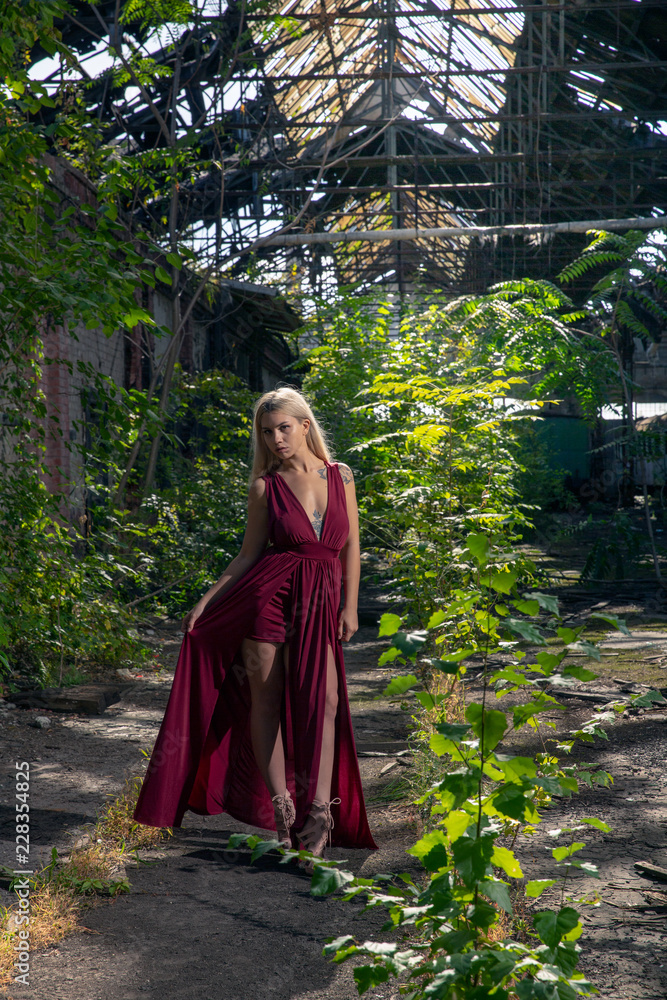 Beautiful woman in red dress at the abandoned train graveyard hall in Budapest Beautiful woman in red dress at the abandoned train graveyard hall in Budapest