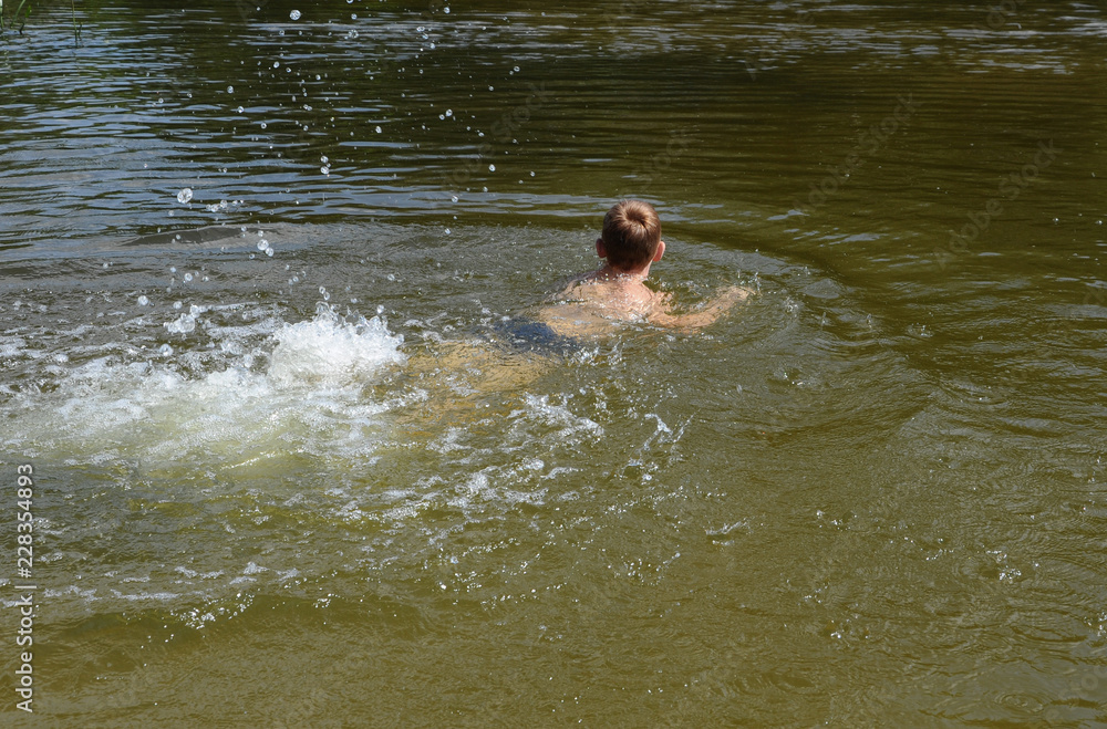 The boy is bathing on the river. The boy is bathing on the river.