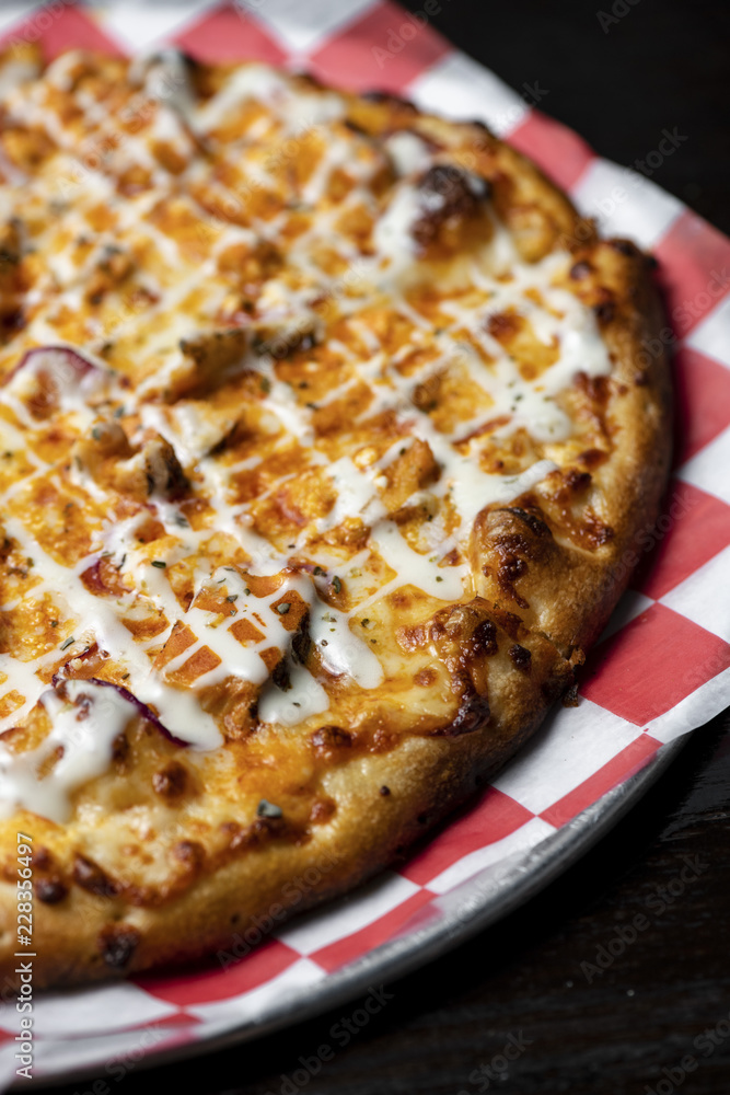 A Gournet Pizza on a red and white check cloth A Gournet Pizza on a red and white check cloth