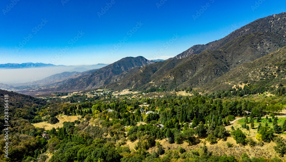 Aerial, drone view of Oak Glen located between the San Bernardino Mountains and Little San Bernardino Mountains with several apple orchards before the Fall color change