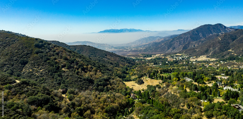 Fototapeta premium Aerial, drone view of Oak Glen located between the San Bernardino Mountains and Little San Bernardino Mountains with several apple orchards before the Fall color change