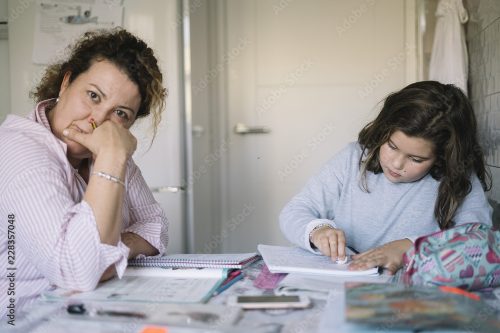 Mother who helps her daughter with the school homework Mother who helps her daughter with the school homework