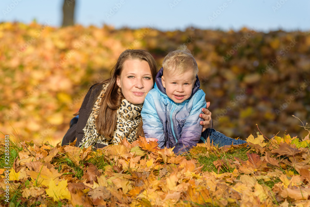 Mom and child in the fallen leaves Mom and child in the fallen leaves