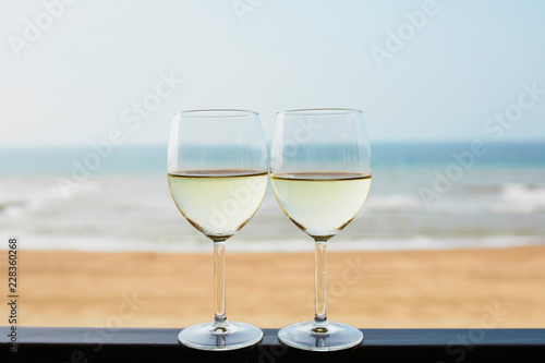 Two glasses of white wine with Atlantic coast beach in background