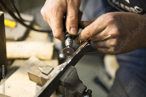 Obraz na płótnie Artisan en train de graver une lame de couteau