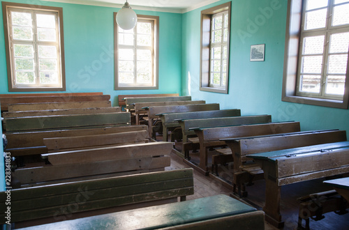 Altes Klassenzimmer einer Schule mit Holzb  nken und Holztischen