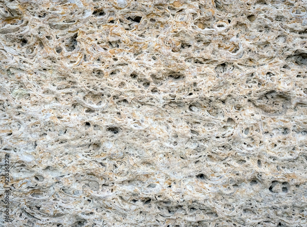 texture of uneven stone wall with pits and holes texture of uneven stone wall with pits and holes