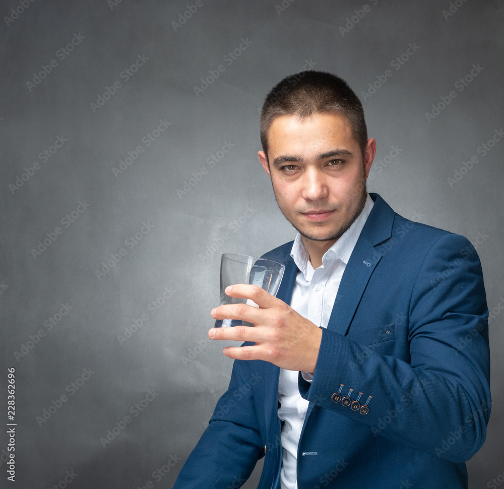 Handsome successfull businessman in blue suit sitting and showing expressions Handsome successfull businessman in blue suit sitting and showing expressions